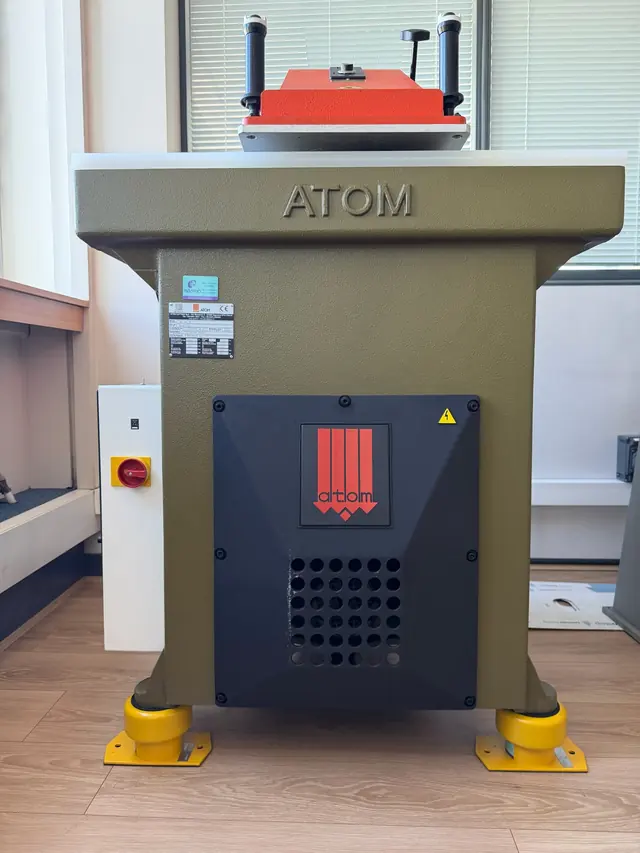 Presse à découper Atom, bâti en fonte et bras de presse rouge.